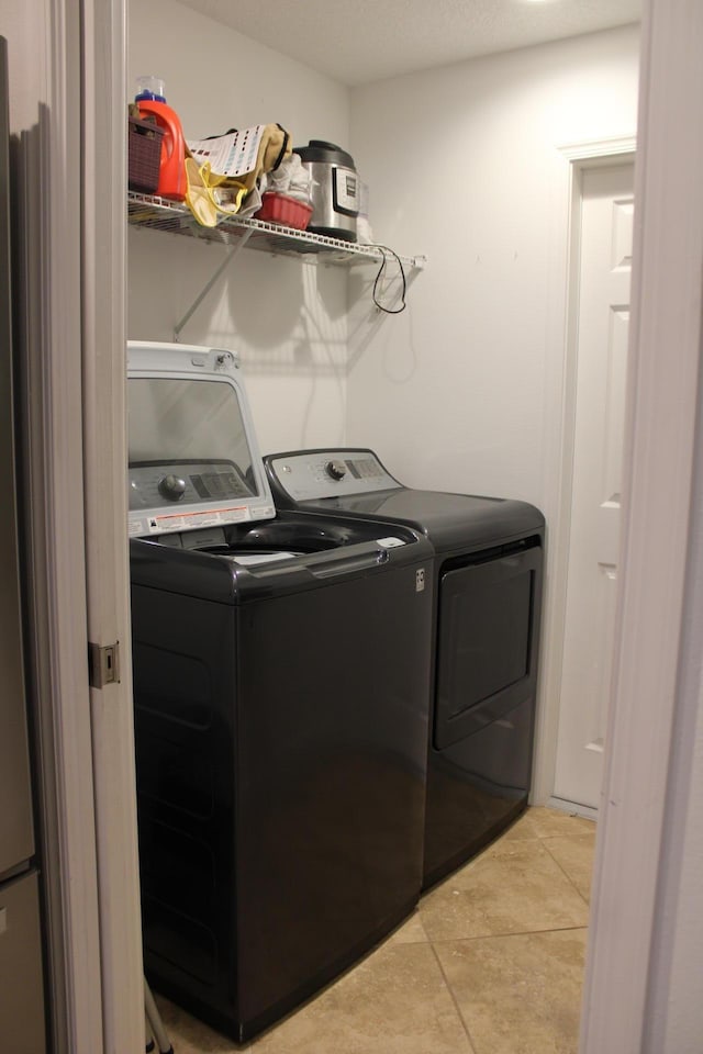 washroom with light tile patterned floors, independent washer and dryer, and laundry area