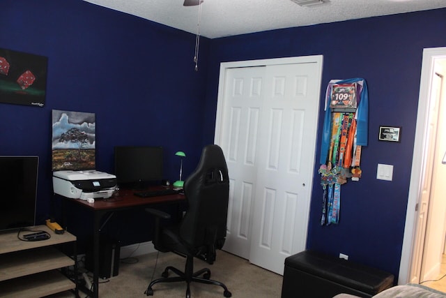 carpeted office space featuring visible vents and a ceiling fan