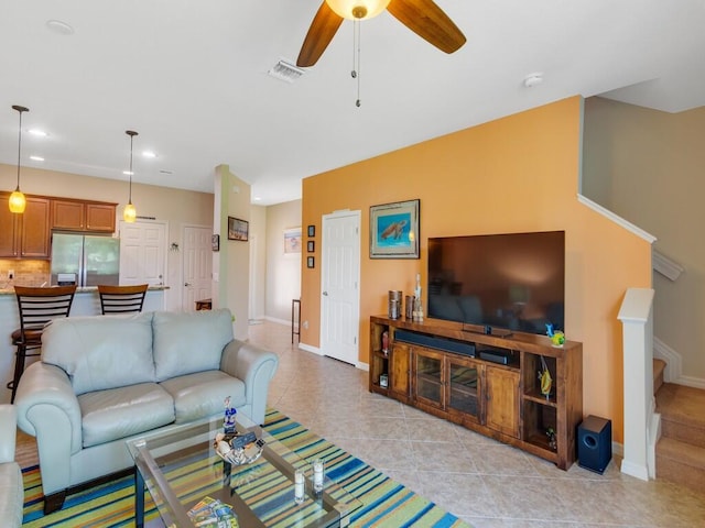living room with ceiling fan, light tile patterned floors, baseboards, recessed lighting, and stairway