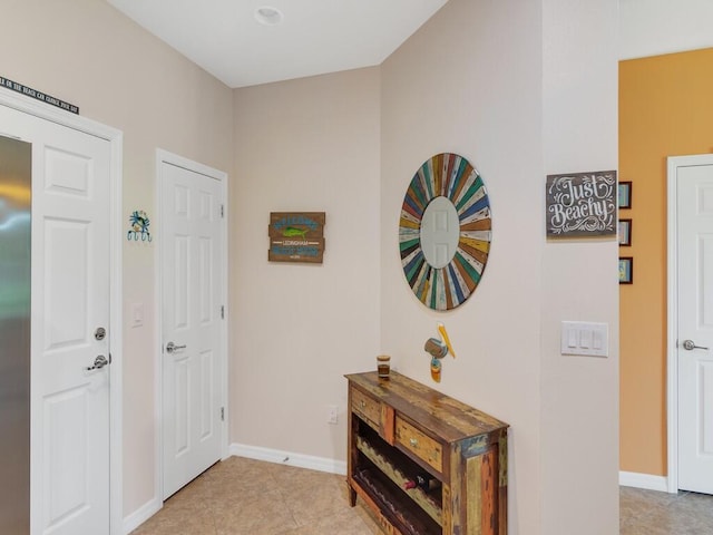 foyer entrance featuring baseboards and light tile patterned floors