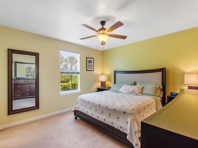 carpeted bedroom featuring baseboards and ceiling fan