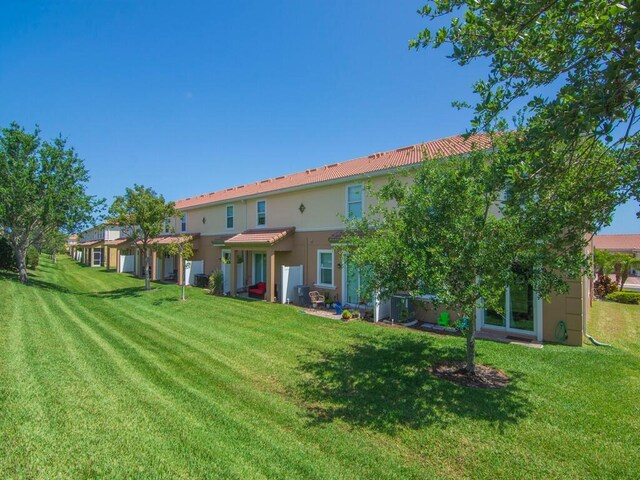 back of property featuring a yard and stucco siding
