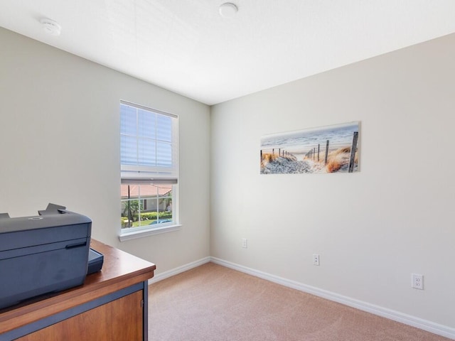 home office featuring light carpet and baseboards
