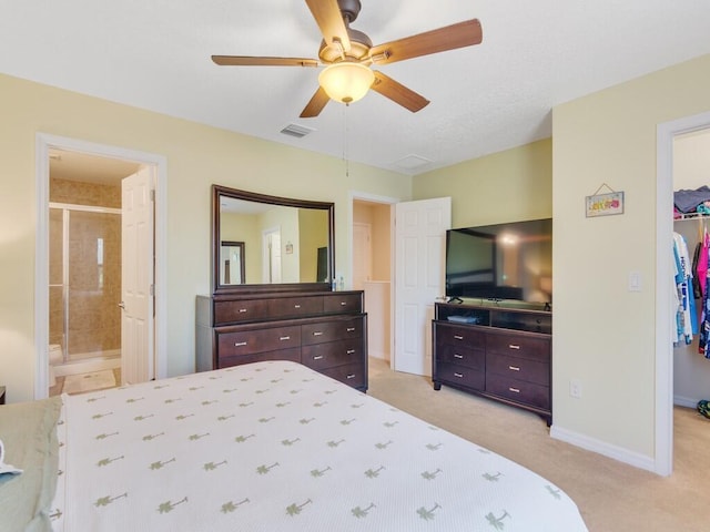 bedroom featuring a spacious closet, a closet, light carpet, baseboards, and ensuite bathroom