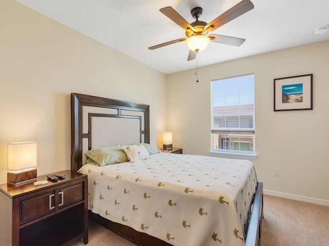 bedroom featuring light carpet, baseboards, and a ceiling fan