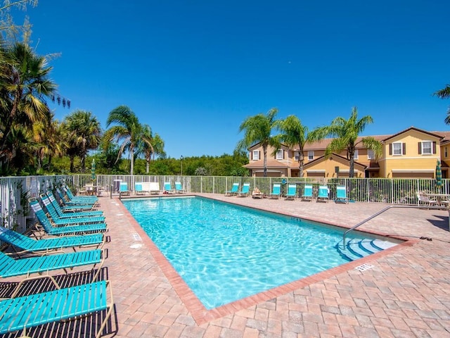 community pool featuring fence and a patio area