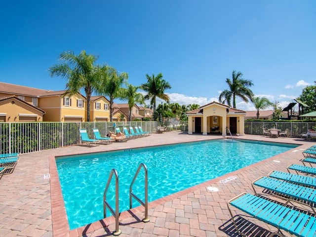 community pool with fence and a patio area