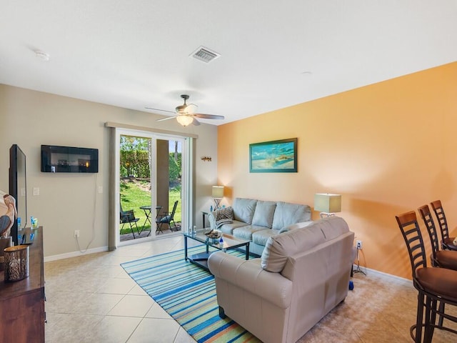 living area featuring a ceiling fan, baseboards, and light tile patterned floors