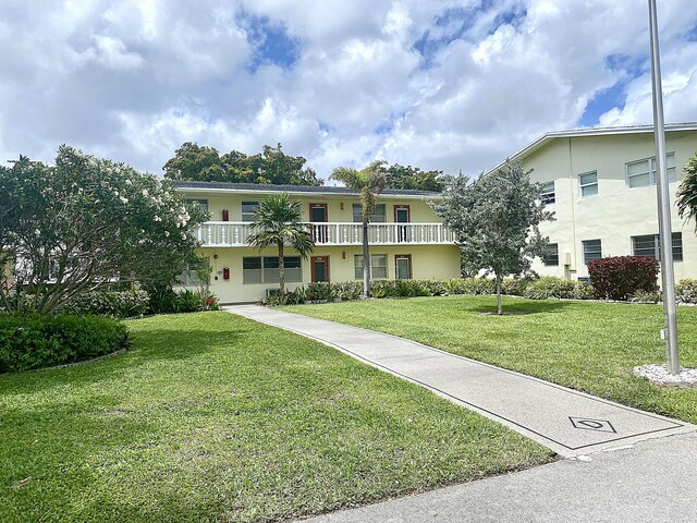 191 Durham D, Deerfield Beach, FL 33442 - view of front of house featuring a front lawn, a balcony, and stucco siding
