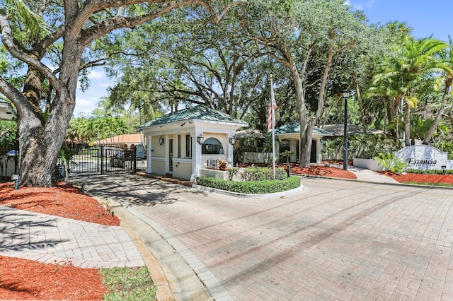 6769 Entrada Pl, Boca Raton, FL 33433 - view of front of property featuring a gate, decorative driveway, stucco siding, and a metal roof