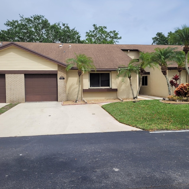 135 Meander Cir, Royal Palm Beach, FL 33411 - ranch-style home featuring concrete driveway, roof with shingles, an attached garage, brick siding, and a front lawn