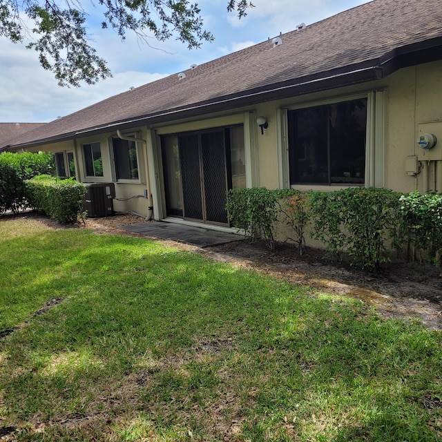 135 Meander Cir, Royal Palm Beach, FL 33411 - rear view of property with a lawn, roof with shingles, central air condition unit, and stucco siding
