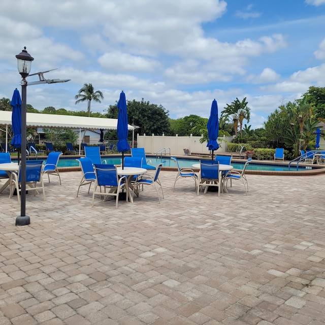 135 Meander Cir, Royal Palm Beach, FL 33411 - exterior space with fence, outdoor dining space, and a community pool