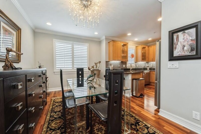 310 E Mallory Cir, Delray Beach, FL 33483 - dining room with crown molding, a notable chandelier, dark wood finished floors, and baseboards
