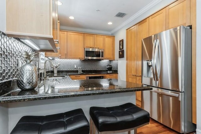 310 E Mallory Cir, Delray Beach, FL 33483 - kitchen with crown molding, a peninsula, visible vents, a sink, and stainless steel appliances