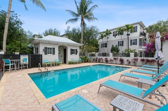310 E Mallory Cir, Delray Beach, FL 33483 - pool featuring a patio, an outbuilding, and fence