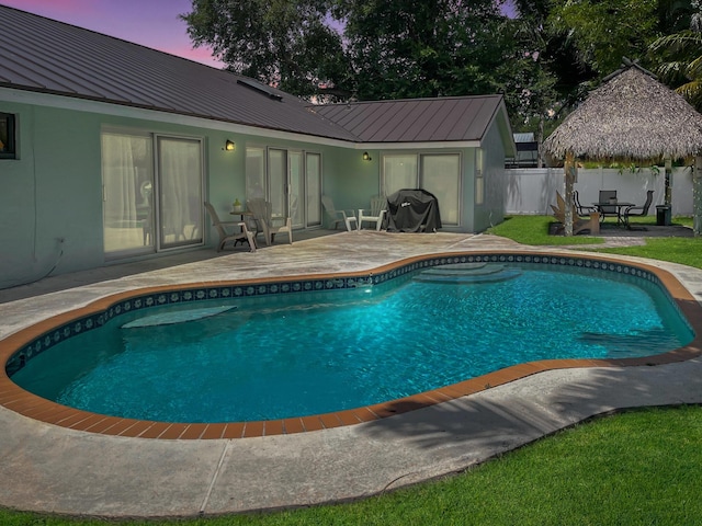1380 SW 1st St, Boca Raton, FL 33486 - pool at dusk featuring a patio and a fenced backyard