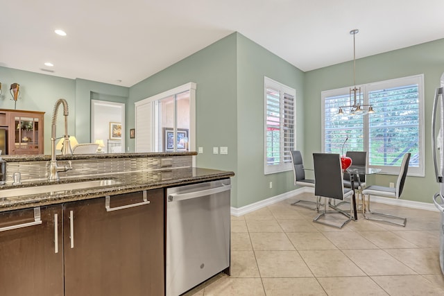 9068 Clearhill Rd, Boynton Beach, FL 33473 - kitchen with dishwasher, baseboards, a sink, and dark stone counters