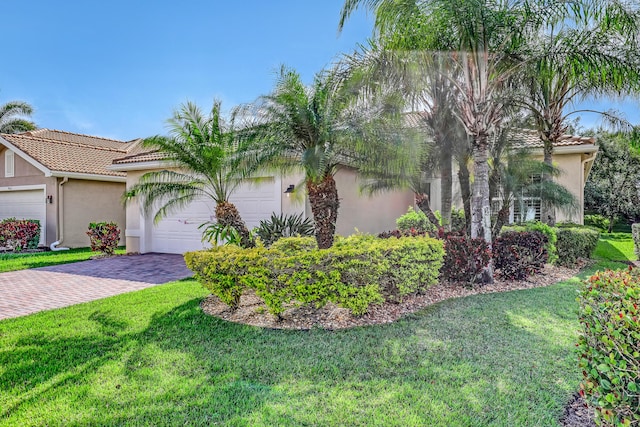 9068 Clearhill Rd, Boynton Beach, FL 33473 - view of front facade with a front lawn, a garage, stucco siding, and a tile roof
