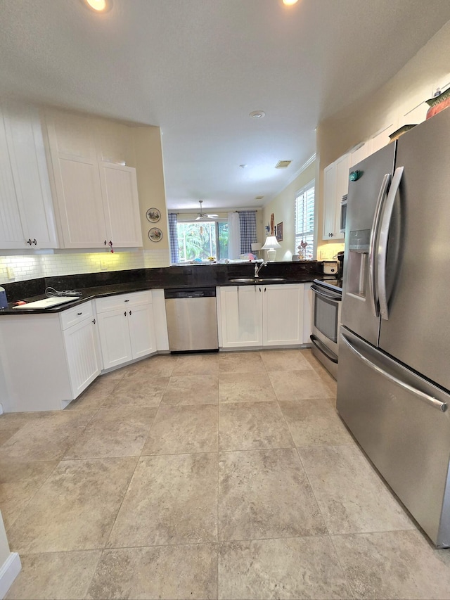 630 SW Treasure Cv, Port Saint Lucie, FL 34953 - kitchen featuring white cabinetry, appliances with stainless steel finishes, a sink, and tasteful backsplash