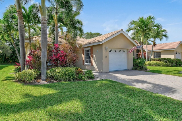 630 SW Treasure Cv, Port Saint Lucie, FL 34953 - ranch-style home with a garage, stucco siding, a front yard, decorative driveway, and a tiled roof