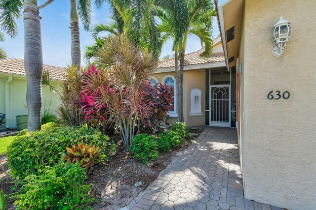 630 SW Treasure Cv, Port Saint Lucie, FL 34953 - view of exterior entry featuring stucco siding and a tiled roof