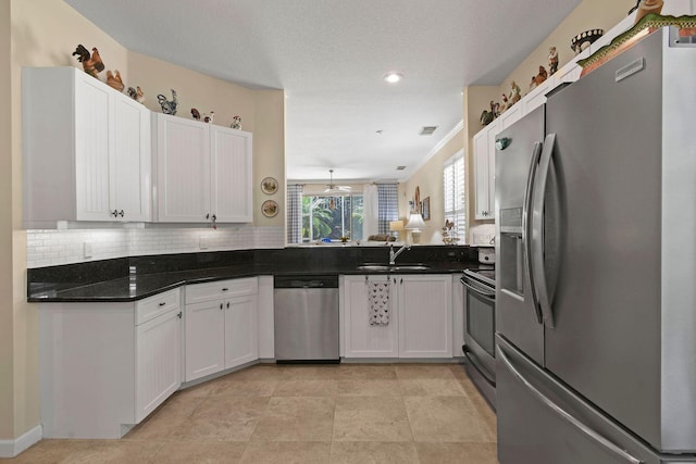 630 SW Treasure Cv, Port Saint Lucie, FL 34953 - kitchen with a sink, appliances with stainless steel finishes, decorative backsplash, and white cabinetry