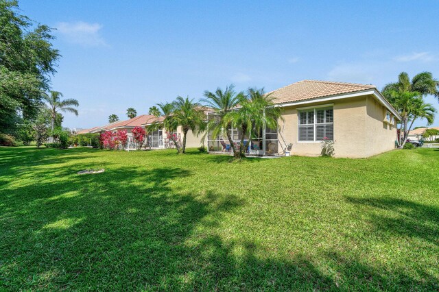 630 SW Treasure Cv, Port Saint Lucie, FL 34953 - back of property featuring a tiled roof, stucco siding, and a yard