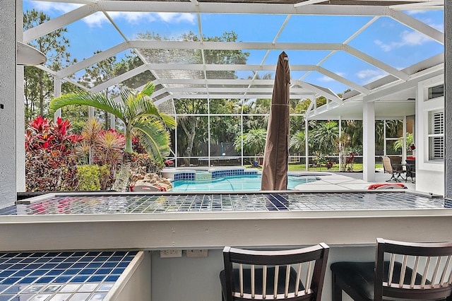 outdoor pool featuring a patio, outdoor dry bar, and a lanai