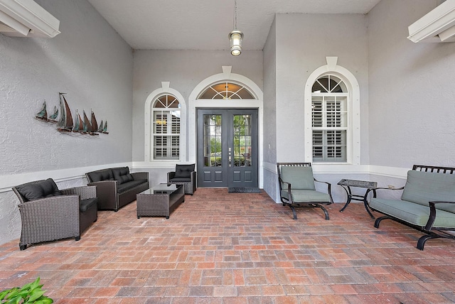 view of exterior entry with outdoor lounge area, french doors, and stucco siding
