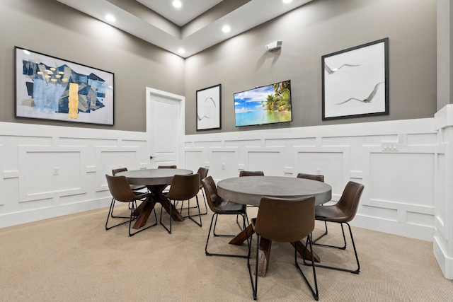 dining space with light carpet, a wainscoted wall, recessed lighting, and a decorative wall