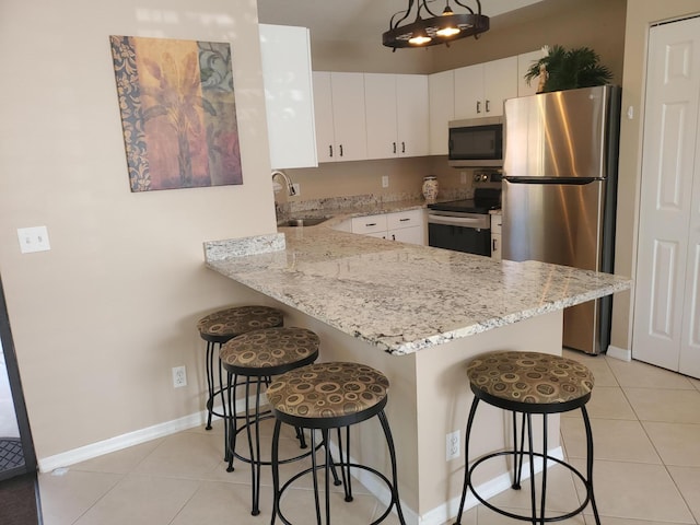 2831 Stoneway Ln Unit C, Fort Pierce, FL 34982 - kitchen featuring light tile patterned floors, white cabinets, a sink, a peninsula, and stainless steel appliances