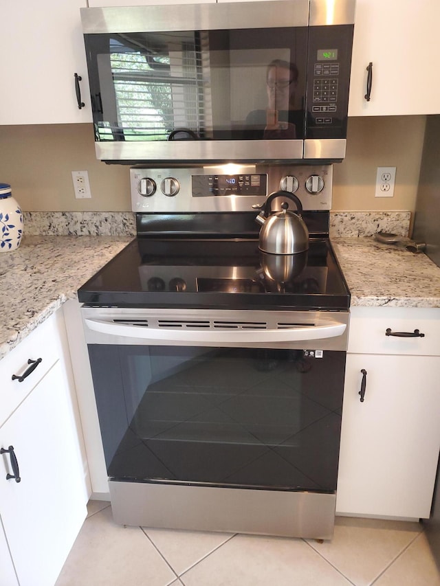 2831 Stoneway Ln Unit C, Fort Pierce, FL 34982 - interior space featuring white cabinets, light tile patterned floors, light stone counters, and appliances with stainless steel finishes
