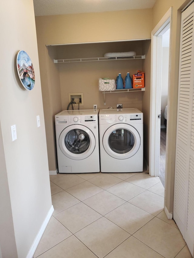 2831 Stoneway Ln Unit C, Fort Pierce, FL 34982 - clothes washing area featuring laundry area, light tile patterned flooring, baseboards, and washing machine and dryer