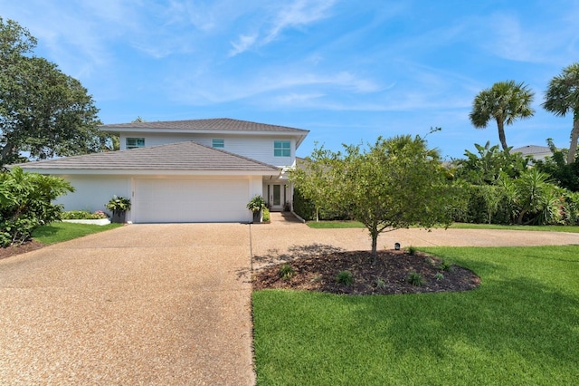 traditional-style house with concrete driveway, a front lawn, an attached garage, and stucco siding