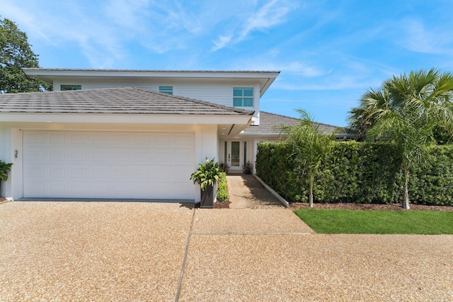 traditional-style home featuring a garage and concrete driveway