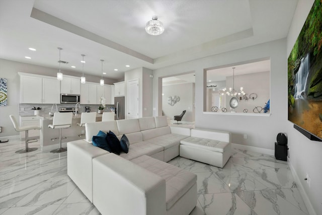 15649 Orchard Dr, Westlake, FL 33470 - living room featuring a tray ceiling, recessed lighting, a chandelier, marble finish floor, and baseboards