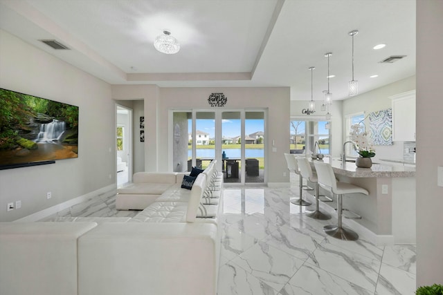 15649 Orchard Dr, Westlake, FL 33470 - living room with a water view, visible vents, baseboards, and marble finish floor