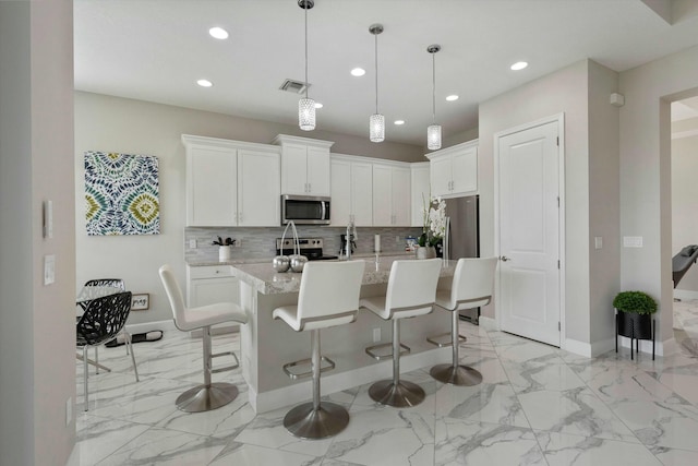15649 Orchard Dr, Westlake, FL 33470 - kitchen with stainless steel appliances, recessed lighting, baseboards, and a kitchen bar