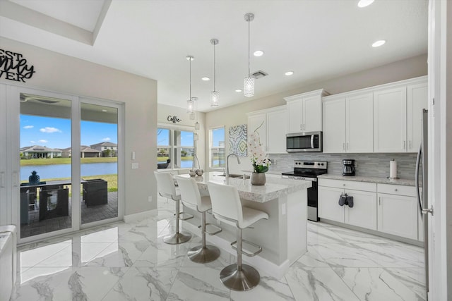 15649 Orchard Dr, Westlake, FL 33470 - kitchen with backsplash, white cabinets, visible vents, stainless steel appliances, and marble finish floor