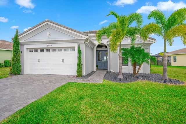 15649 Orchard Dr, Westlake, FL 33470 - single story home featuring a tiled roof, stucco siding, decorative driveway, a front lawn, and a garage
