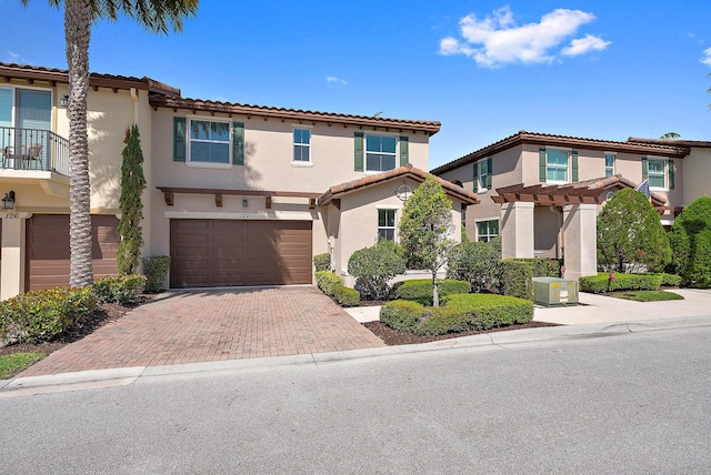 122 Diamante Way, Jupiter, FL 33477 - view of front of home with stucco siding, an attached garage, decorative driveway, a pergola, and a tile roof