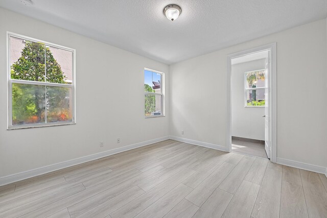 122 Diamante Way, Jupiter, FL 33477 - unfurnished room with light wood-style flooring, baseboards, and a textured ceiling