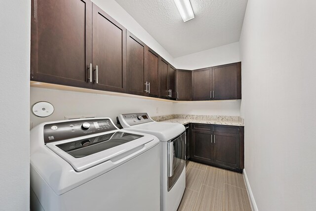 122 Diamante Way, Jupiter, FL 33477 - laundry room with separate washer and dryer, cabinet space, baseboards, and a textured ceiling