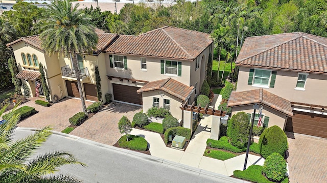 122 Diamante Way, Jupiter, FL 33477 - view of front facade featuring a tiled roof, decorative driveway, stucco siding, and an attached garage