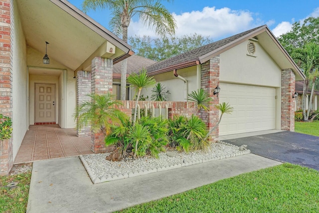 18356 181st Cir S, Boca Raton, FL 33498 - view of front of house featuring aphalt driveway, stucco siding, roof with shingles, brick siding, and a garage