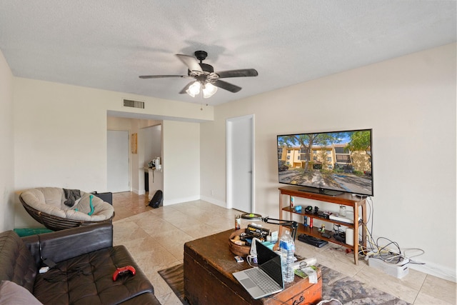 tiled living area with visible vents, baseboards, a ceiling fan, and a textured ceiling