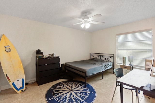bedroom with light tile patterned floors, a ceiling fan, and a textured ceiling