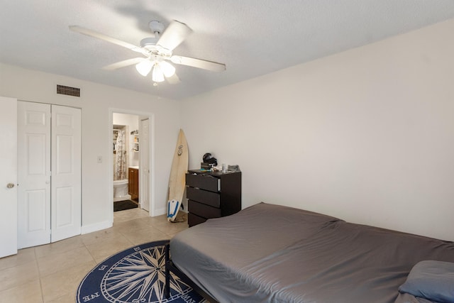 bedroom featuring visible vents, a closet, light tile patterned floors, ceiling fan, and a textured ceiling