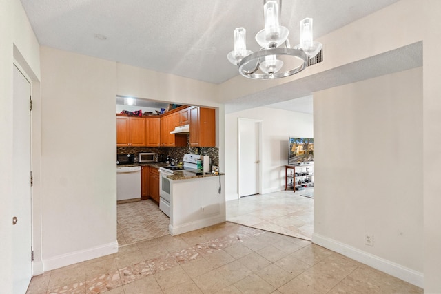 kitchen with an inviting chandelier, white appliances, backsplash, dark countertops, and under cabinet range hood